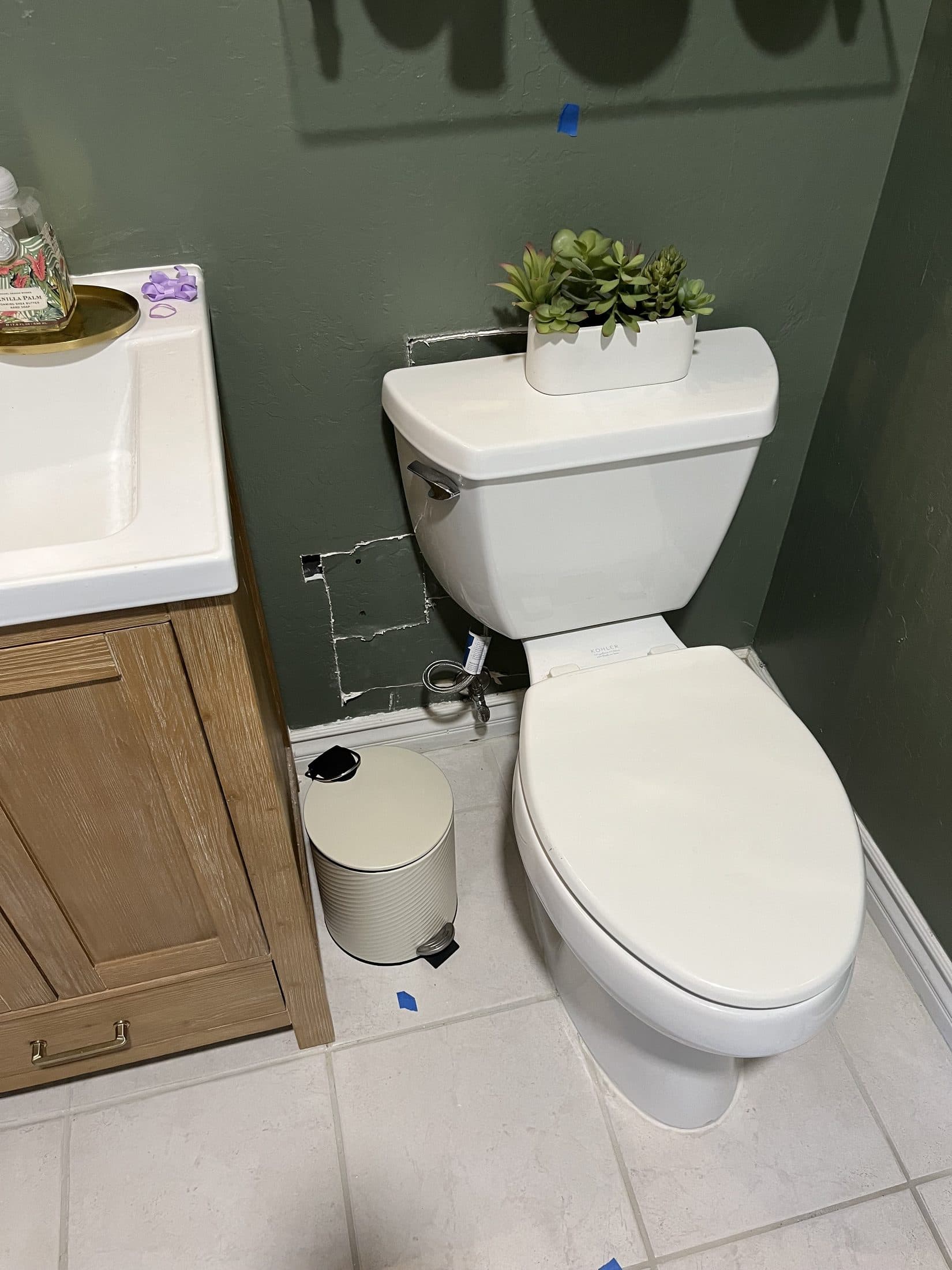Bathroom restored after a slab leak reroute, with the toilet reset and the drywall patched ready for paint